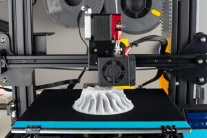 A 3D PRINTER PRINTING A COMPRESSOR WHEEL FOR A CAR.