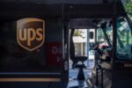 A brown delivery truck with "UPS" emblazoned on the passenger side in yellow lettering
